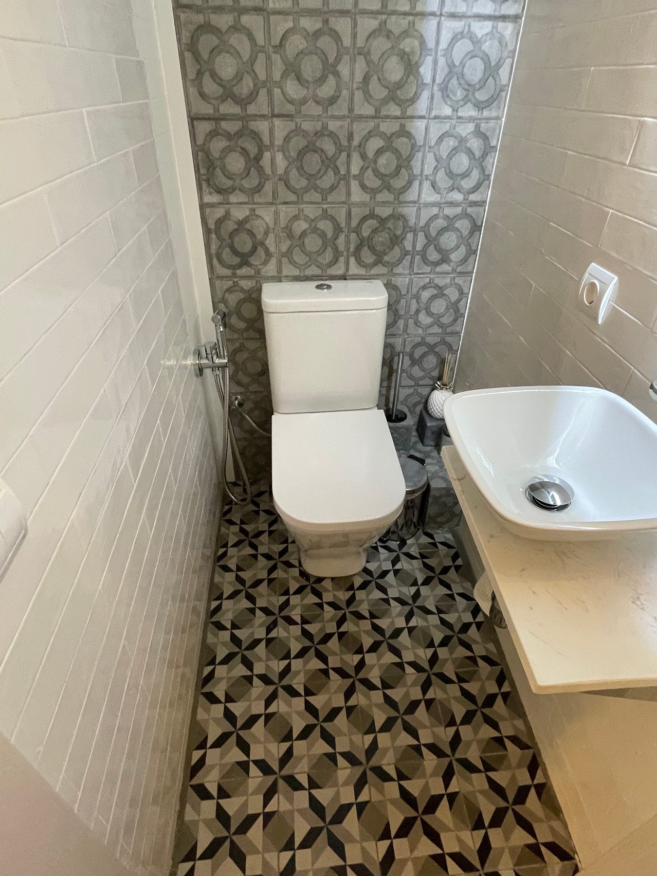 Baño con azulejo de mosaico, suelo hidráulico geométrico y lavabo de diseño en Carrer Viladomat, Barcelona